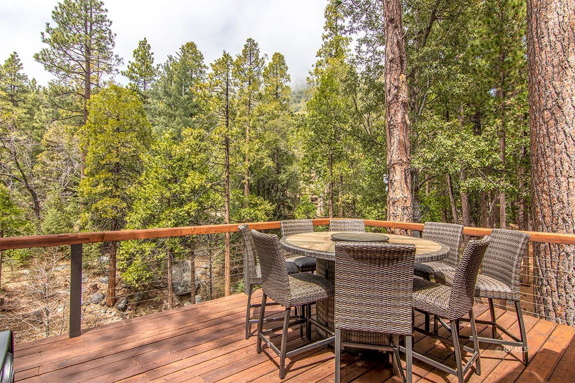 24750 Upper Rim Rock Road Idyllwild, CA 92549 - Photo 40 of 58 a view of a patio with table and chairs and wooden floor