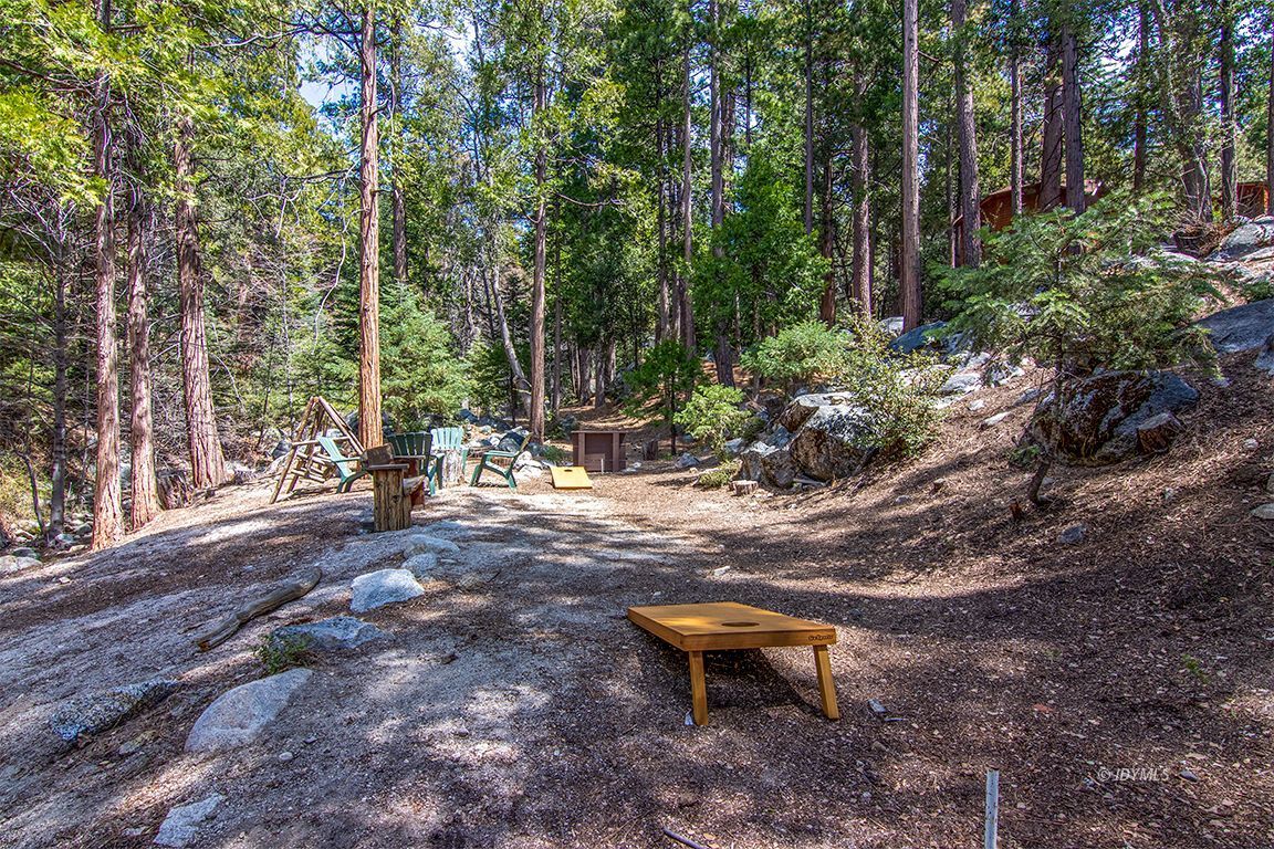 24750 Upper Rim Rock Road Idyllwild, CA 92549 - Photo 47 of 58 a backyard of a house with table and chairs