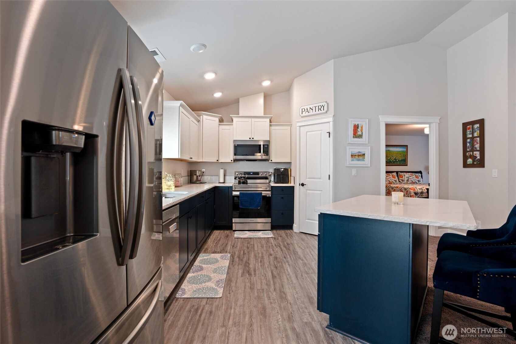 21356 Jefferson Beach Road Northeast Kingston, WA 98346 - Photo 13 of 40 a kitchen with stainless steel appliances a refrigerator a sink dishwasher a stove and white countertops with wooden floor