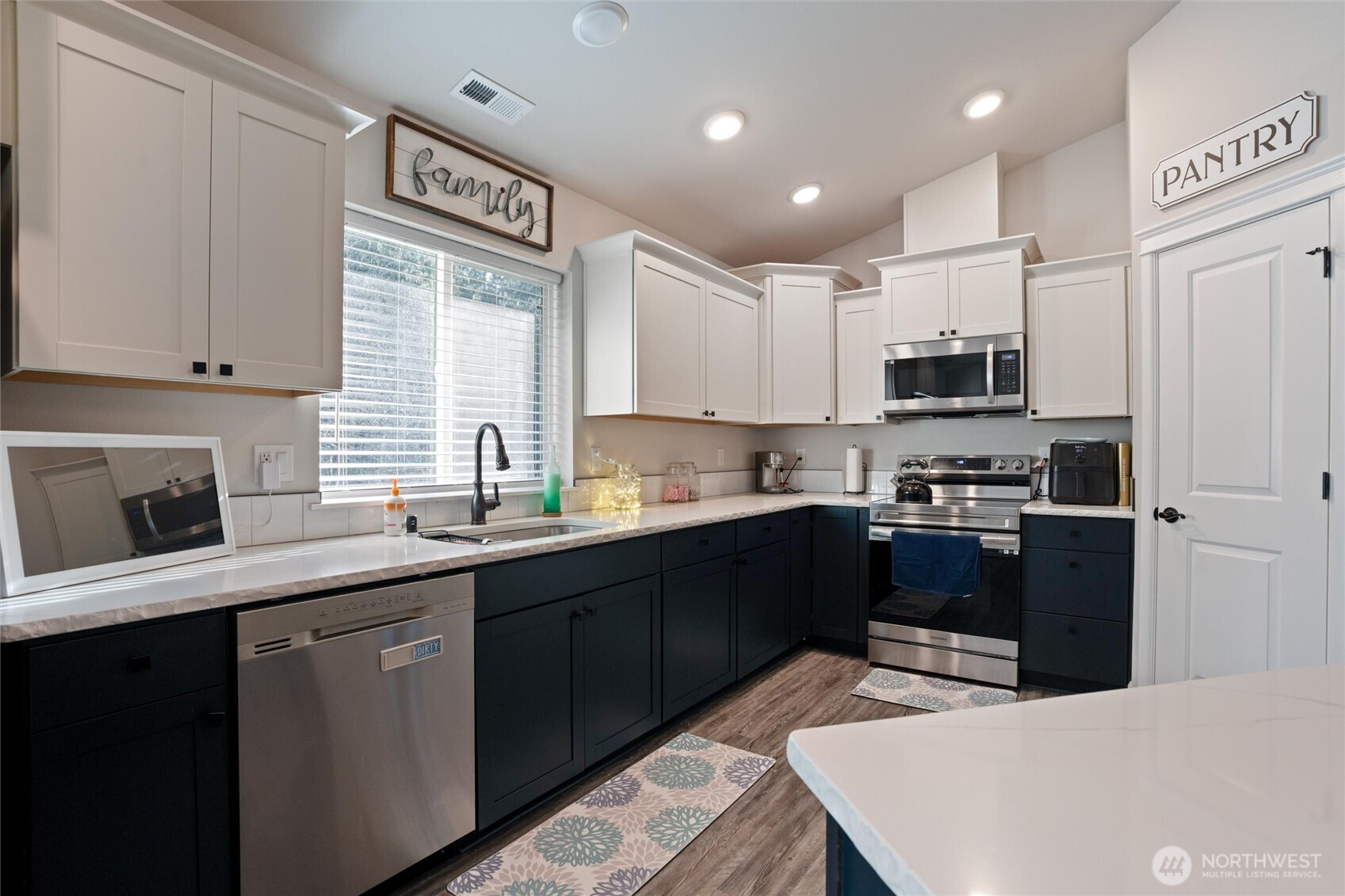 21356 Jefferson Beach Road Northeast Kingston, WA 98346 - Photo 15 of 40 a kitchen with stainless steel appliances granite countertop a refrigerator a sink dishwasher a stove and white cabinets with wooden floor