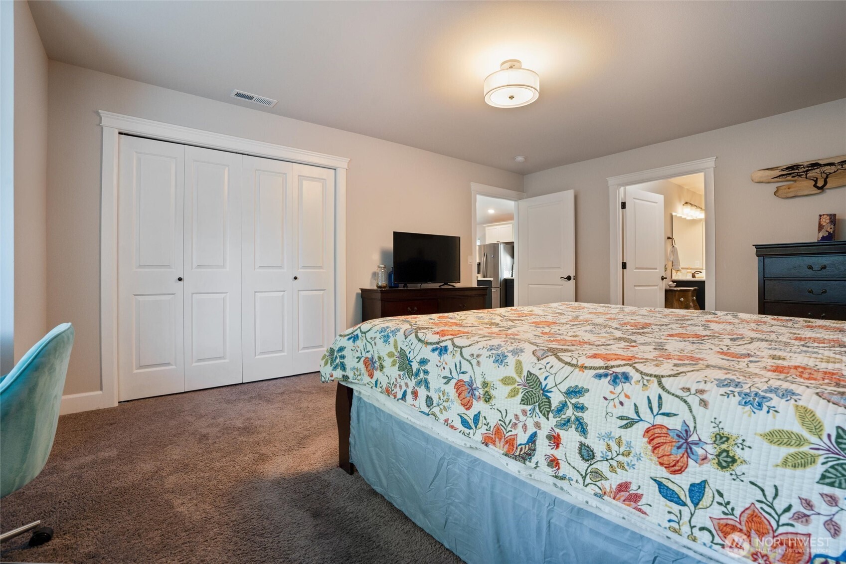 21356 Jefferson Beach Road Northeast Kingston, WA 98346 - Photo 19 of 40 a spacious bedroom with a bed and a flat screen tv