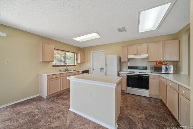 a kitchen with a sink stove and refrigerator