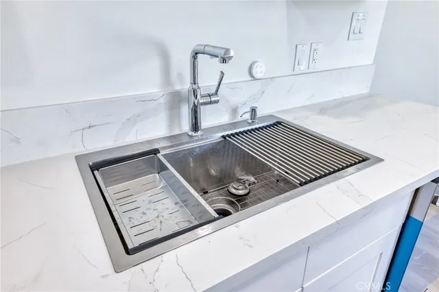 a kitchen with stainless steel appliances granite countertop a sink a stove and a wooden cabinets