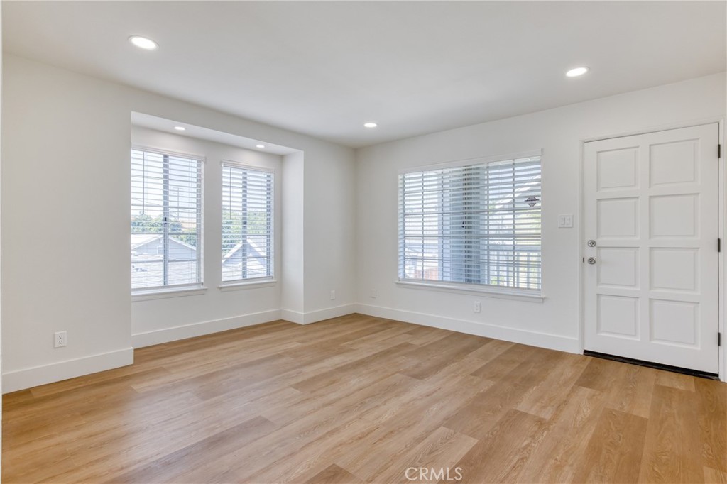 320 West Truslow Avenue, Unit D Fullerton, CA 92832 - Photo 23 of 25 a view of an empty room with a window and wooden floor
