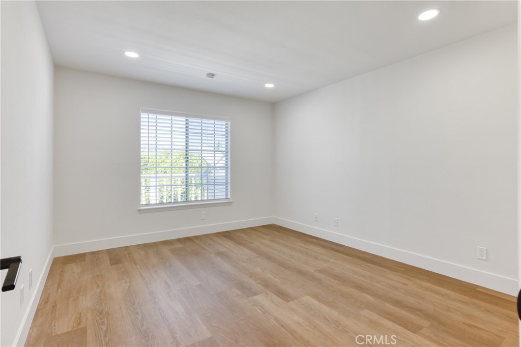 320 West Truslow Avenue, Unit D Fullerton, CA 92832 - Photo 10 of 25 a view of an empty room with wooden floor and a window