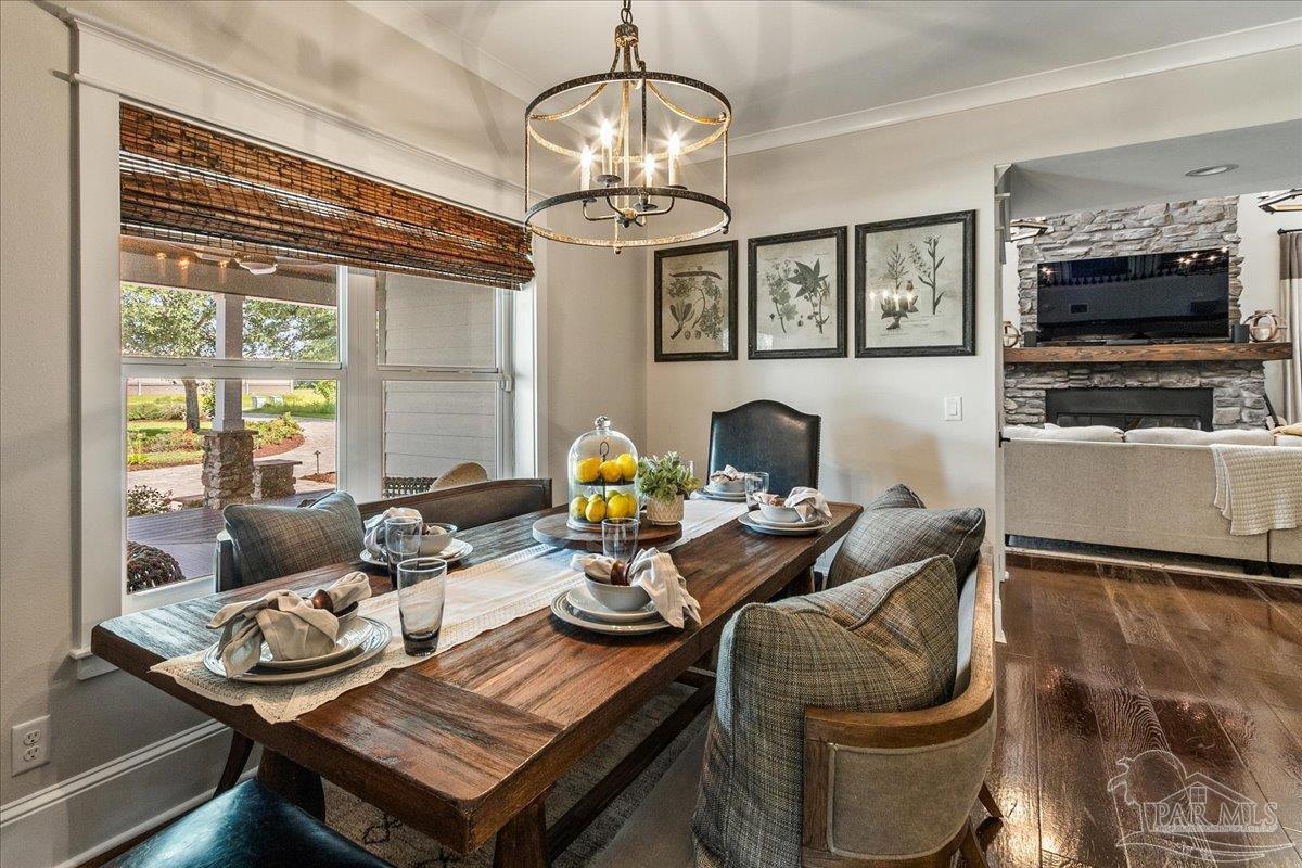 9050 Salter Road Pace, FL 32571 - Photo 11 of 48 a living room with furniture a flat screen tv and a chandelier