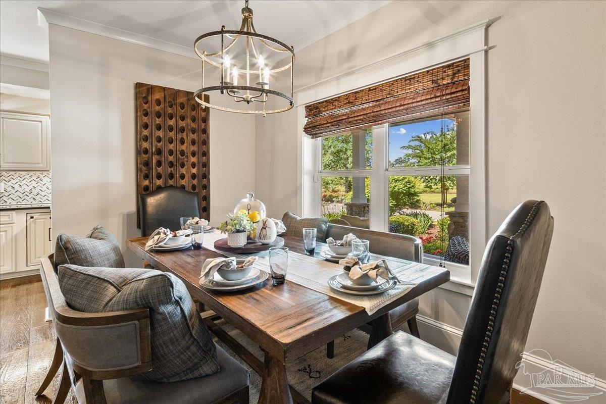 9050 Salter Road Pace, FL 32571 - Photo 12 of 48 a view of a dining room with furniture wooden floor and chandelier