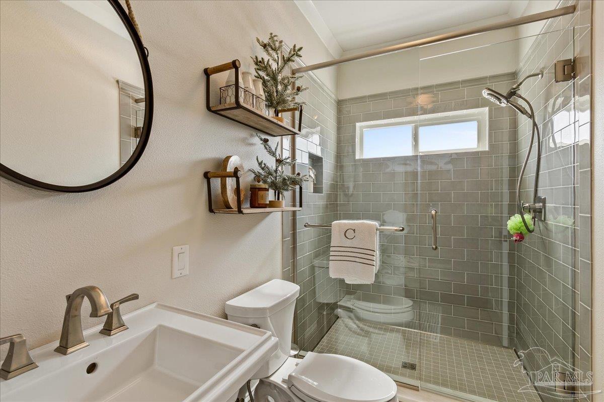 9050 Salter Road Pace, FL 32571 - Photo 16 of 48 a bathroom with a toilet sink and shower