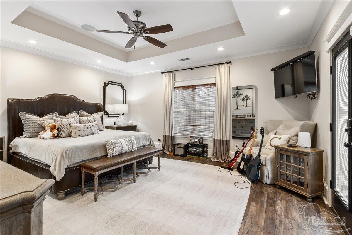 9050 Salter Road Pace, FL 32571 - Photo 17 of 48 a bedroom with furniture a flat screen tv and a ceiling fan