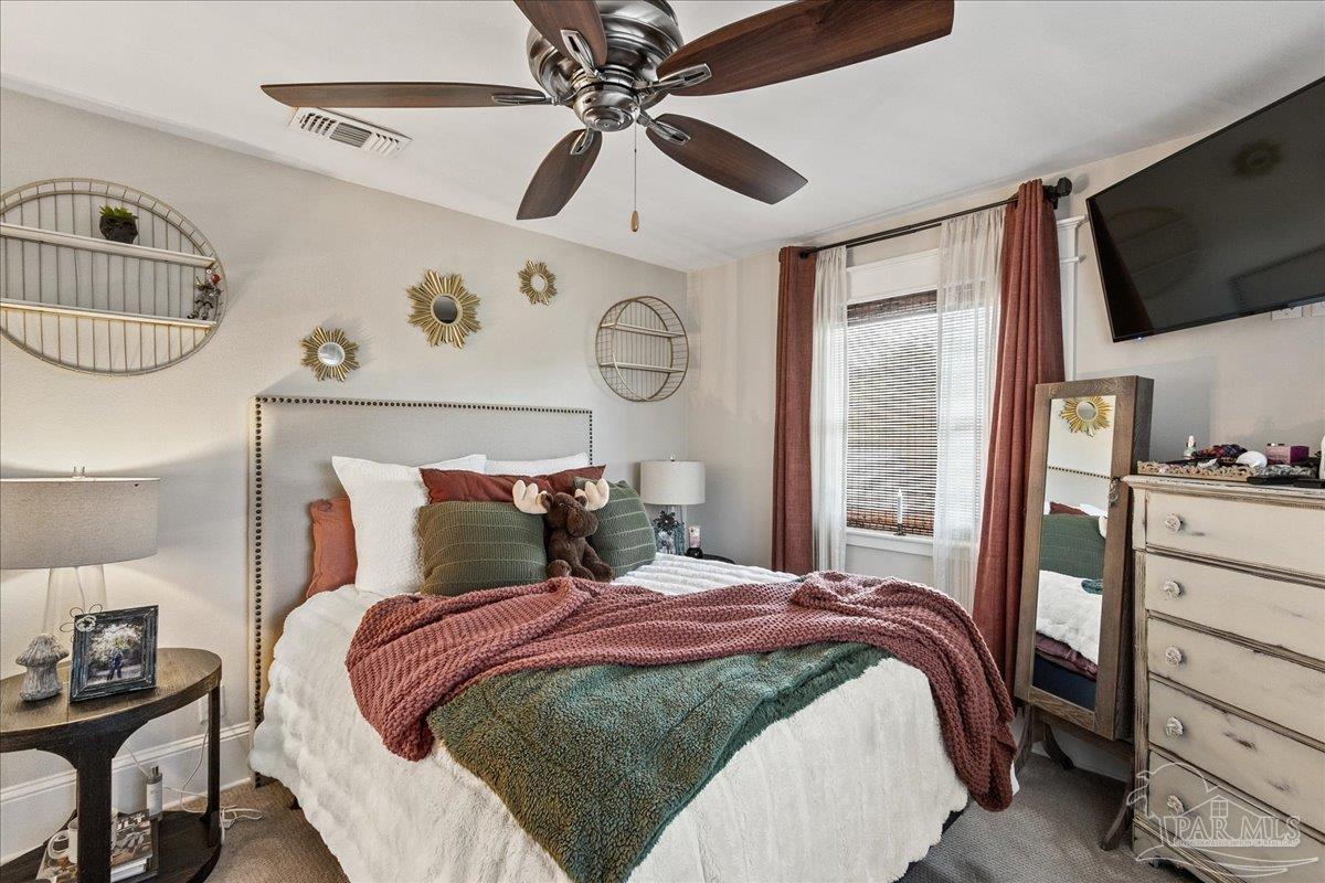 9050 Salter Road Pace, FL 32571 - Photo 27 of 48 a bedroom with a bed and a flat tv screen on the dresser