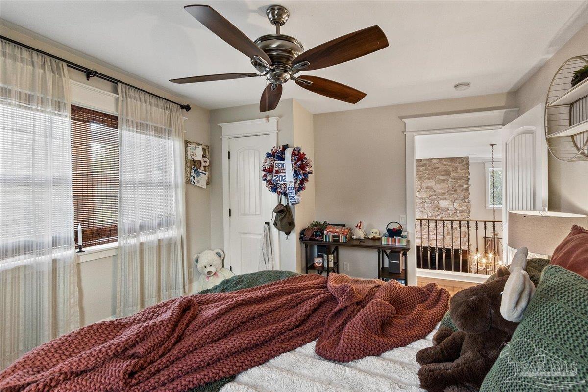 9050 Salter Road Pace, FL 32571 - Photo 28 of 48 a bedroom with a bed and a chandelier