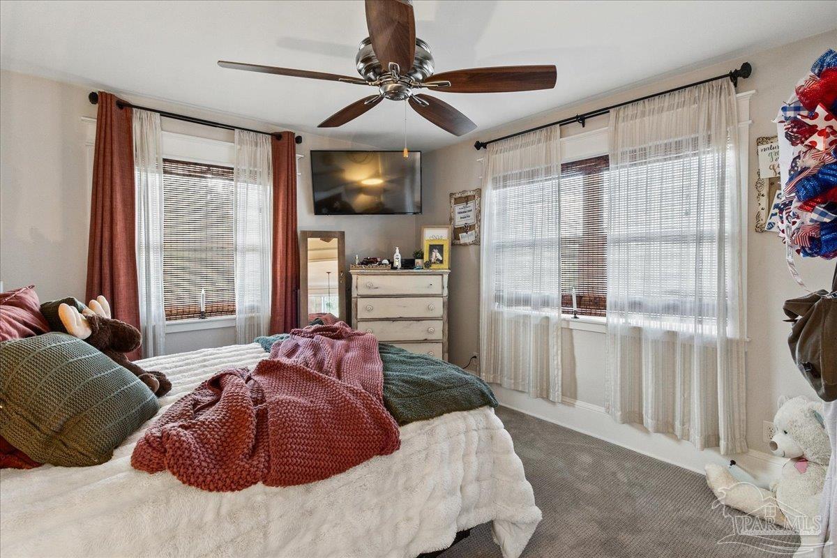 9050 Salter Road Pace, FL 32571 - Photo 29 of 48 a bedroom with a large bed and a flat tv screen