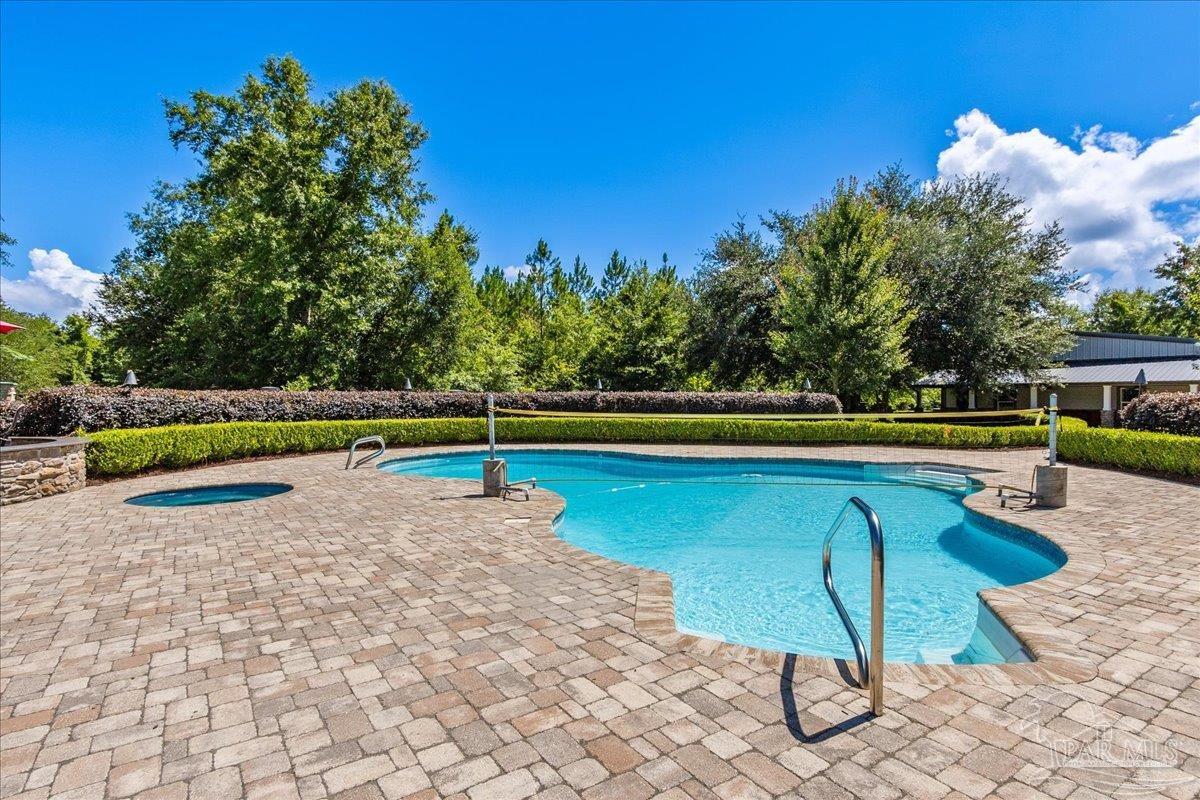 9050 Salter Road Pace, FL 32571 - Photo 35 of 48 a view of a swimming pool with a lounge chair