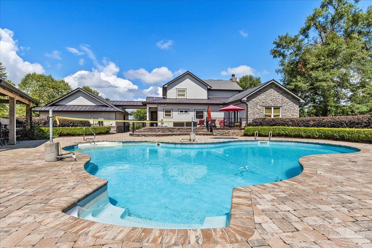 9050 Salter Road Pace, FL 32571 - Photo 36 of 48 a front view of a house with swimming pool having outdoor seating