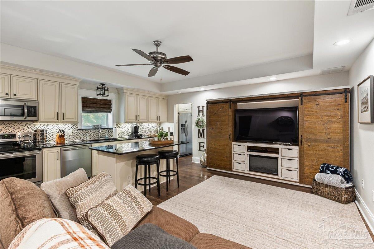 9050 Salter Road Pace, FL 32571 - Photo 41 of 48 a living room with furniture a flat screen tv and kitchen view