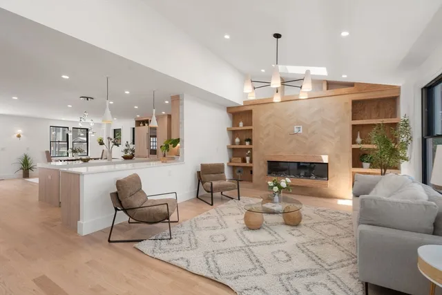 a living room with fireplace furniture and a large window