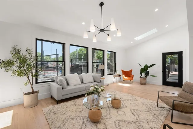 a living room with furniture potted plant and a large window