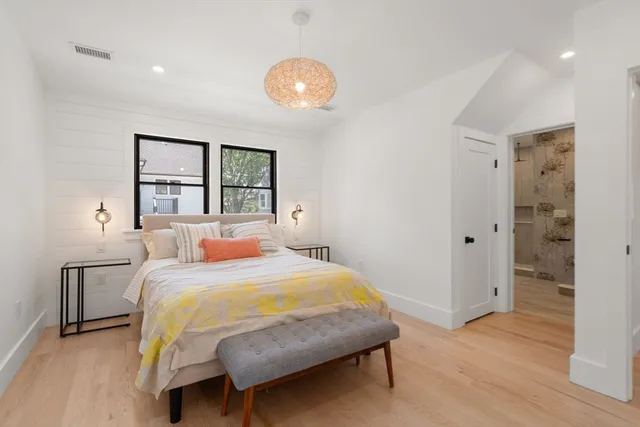 a bedroom with a bed and a chandelier