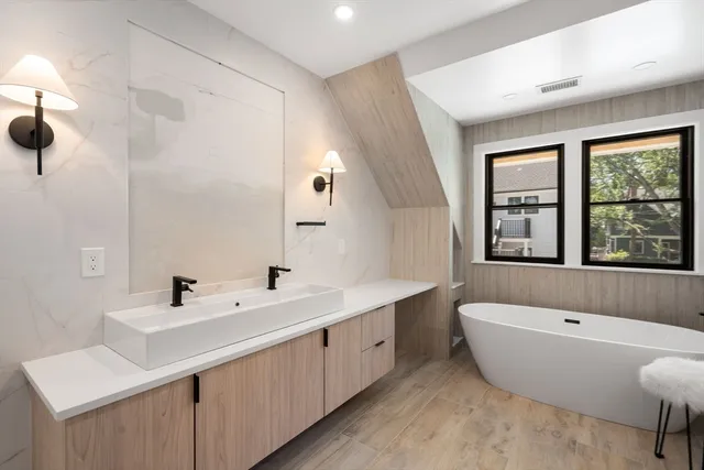 a bathroom with a bathtub sink and mirror