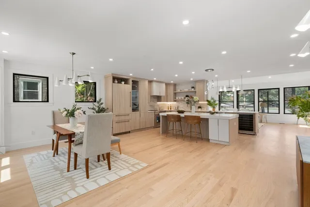 a living room with stainless steel appliances kitchen island granite countertop furniture wooden floor and a kitchen view
