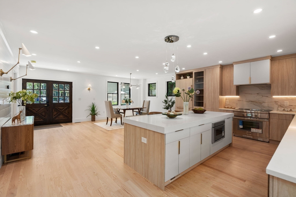 216 Aspinwall Avenue, Unit 3 Brookline, MA 02446 - Photo 7 of 38 a kitchen with stainless steel appliances granite countertop a stove top oven a sink a refrigerator and white cabinets with wooden floor