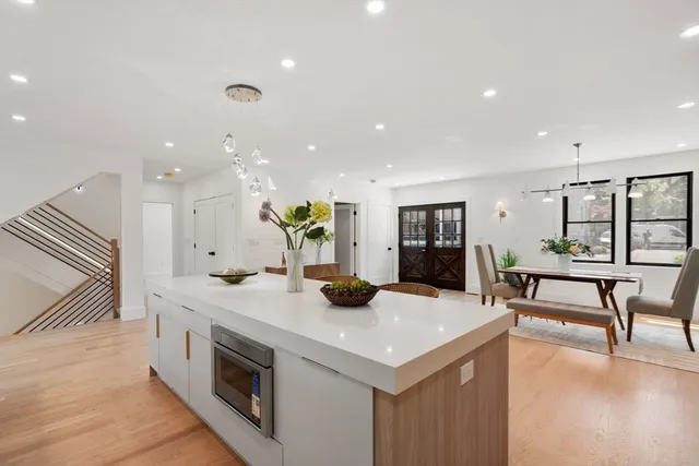 a kitchen with stainless steel appliances white cabinets and wooden floor