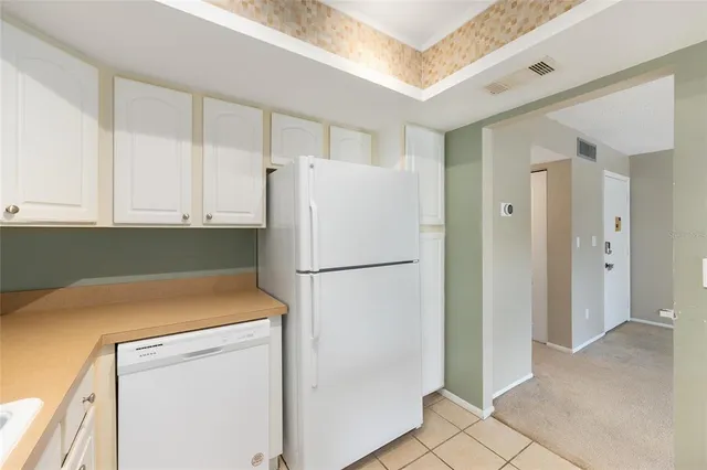 a white refrigerator freezer and a stove sitting inside of a kitchen