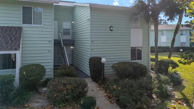 a front view of a house with garden and plants