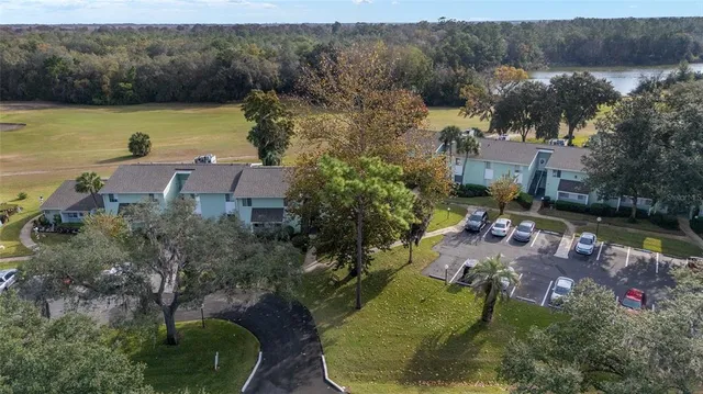 an aerial view of a house with a garden and lake view