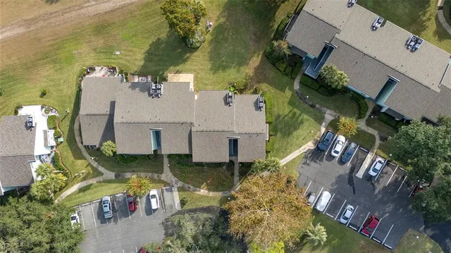 an aerial view of a house with swimming pool and large trees