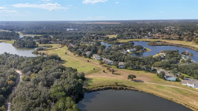 an aerial view of a house with a yard and lake view