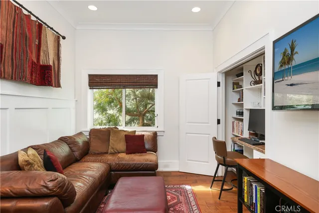 a living room with furniture a desk and chair with windows