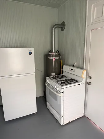 a white refrigerator freezer and a stove sitting inside of a kitchen