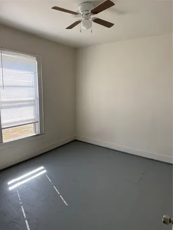 an empty room with a fireplace and windows