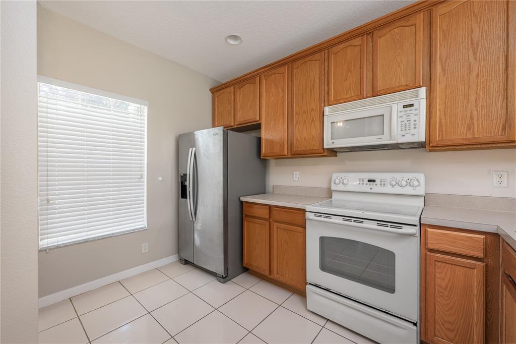 9441 Flowering Cottonwood Road, Unit 41 Orlando, FL 32832 - Photo 5 of 31 a kitchen with a stove microwave and sink