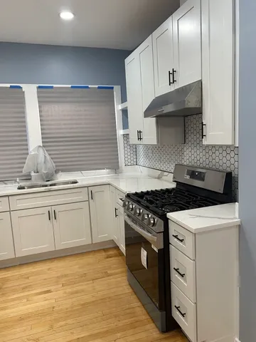 a kitchen with granite countertop white cabinets and appliances