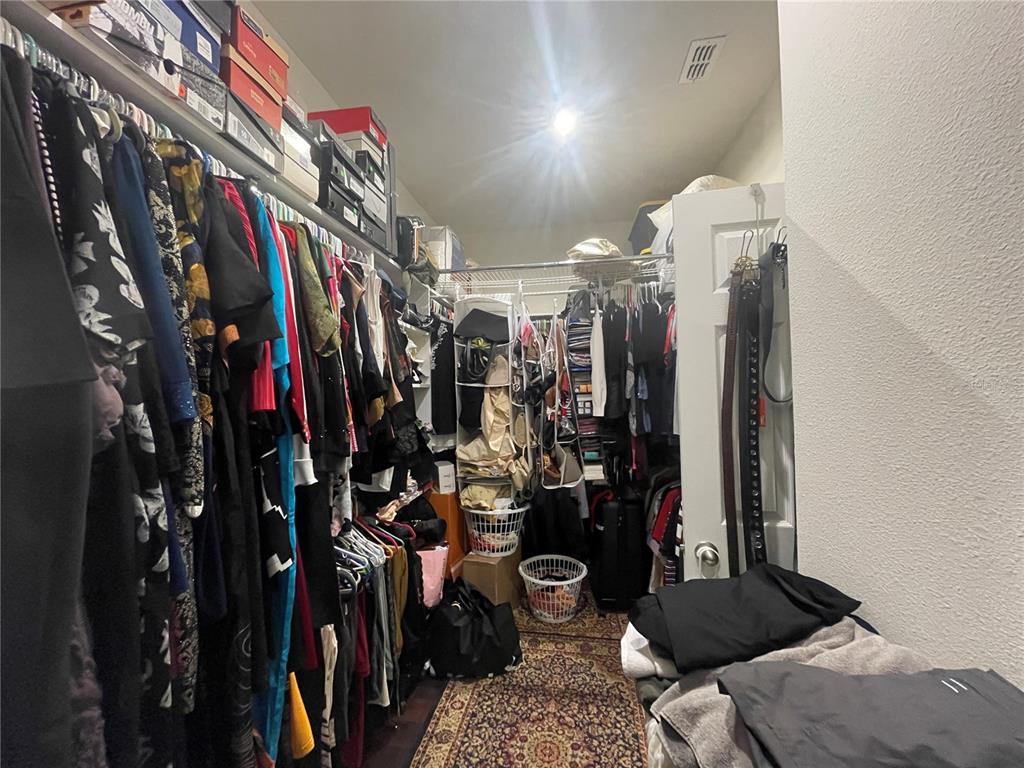 16611 Toccoa Row Winter Garden, FL 34787 - Photo 16 of 31 a view of walk in closet with clothes and shoes