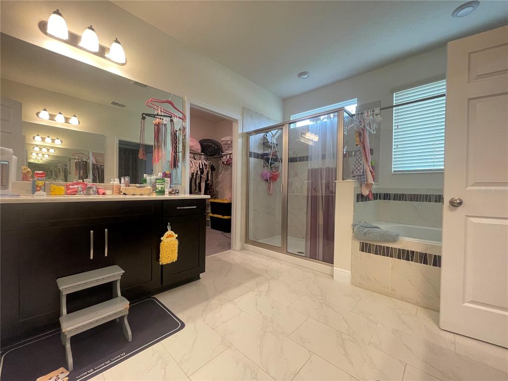 16611 Toccoa Row Winter Garden, FL 34787 - Photo 26 of 31 a dining hall with stainless steel appliances kitchen island granite countertop a refrigerator a stove a sink and a dining table with wooden floor