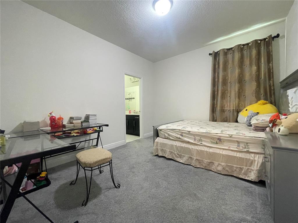 16611 Toccoa Row Winter Garden, FL 34787 - Photo 27 of 31 a bedroom with a bed and a table in it