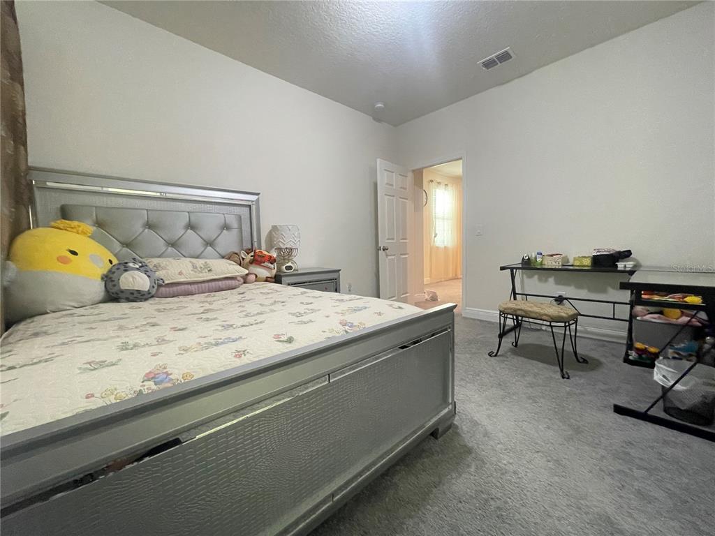 16611 Toccoa Row Winter Garden, FL 34787 - Photo 29 of 31 a bedroom with a bed and a table in it