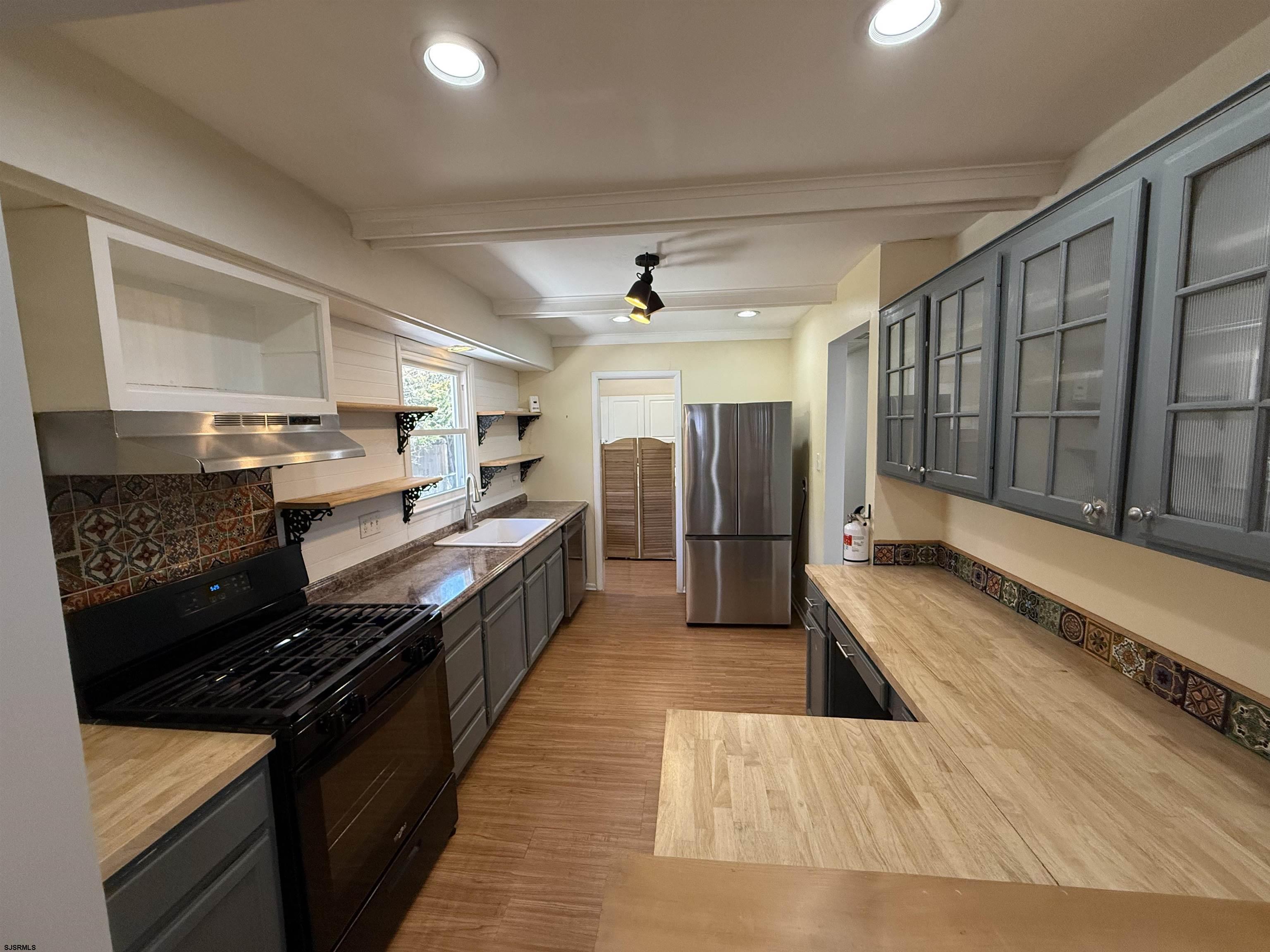 230 Bethel Road Somers Point, NJ 08244 - Photo 2 of 30 a large kitchen with stainless steel appliances a large counter top a stove a chimney a sink and cabinets