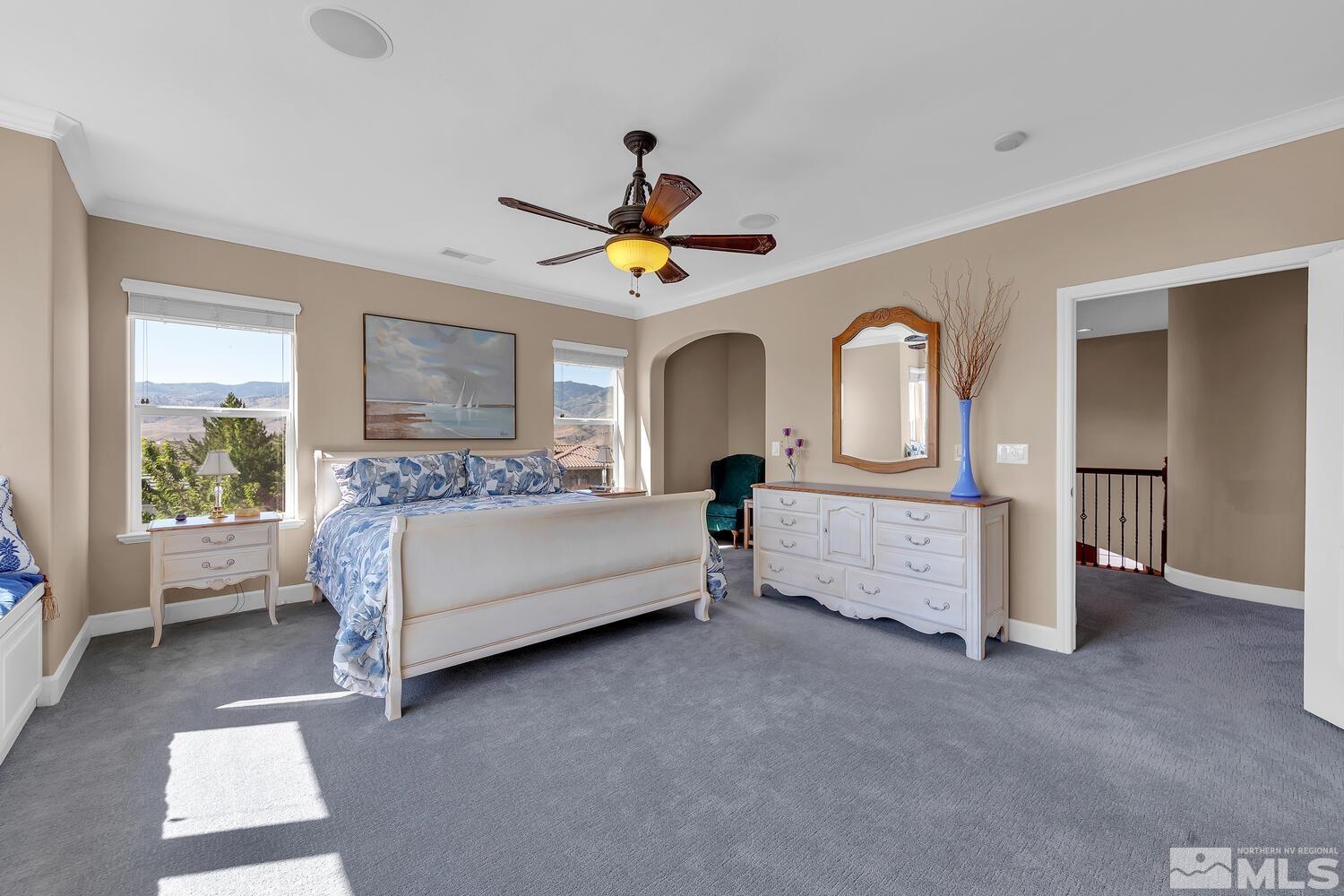 1940 Bechtol Ridge Circle Reno, NV 89523 - Photo 25 of 40 a spacious bedroom with a bed a chandelier and a large window