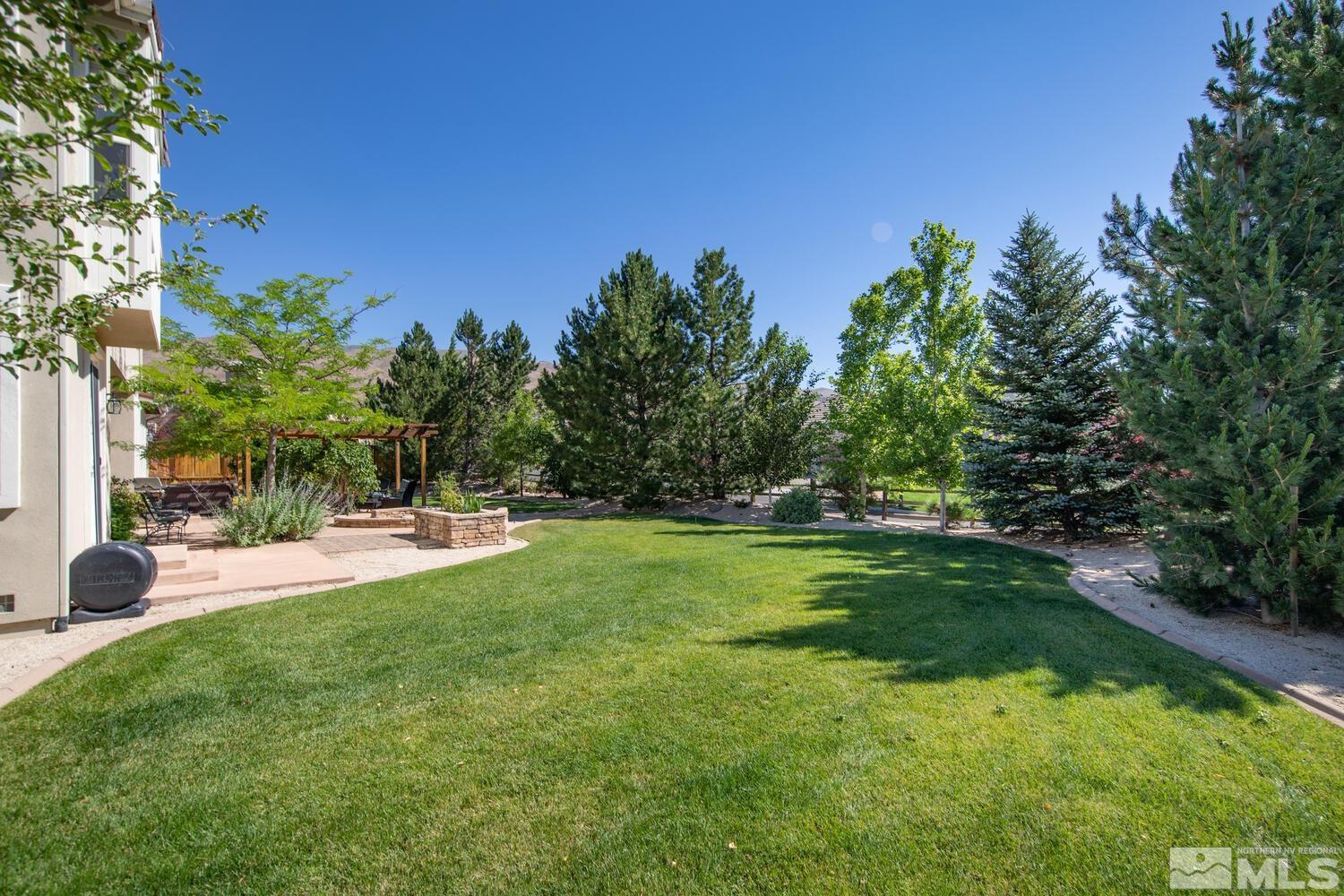 1940 Bechtol Ridge Circle Reno, NV 89523 - Photo 38 of 40 a backyard of a house with table and chairs plants and large trees