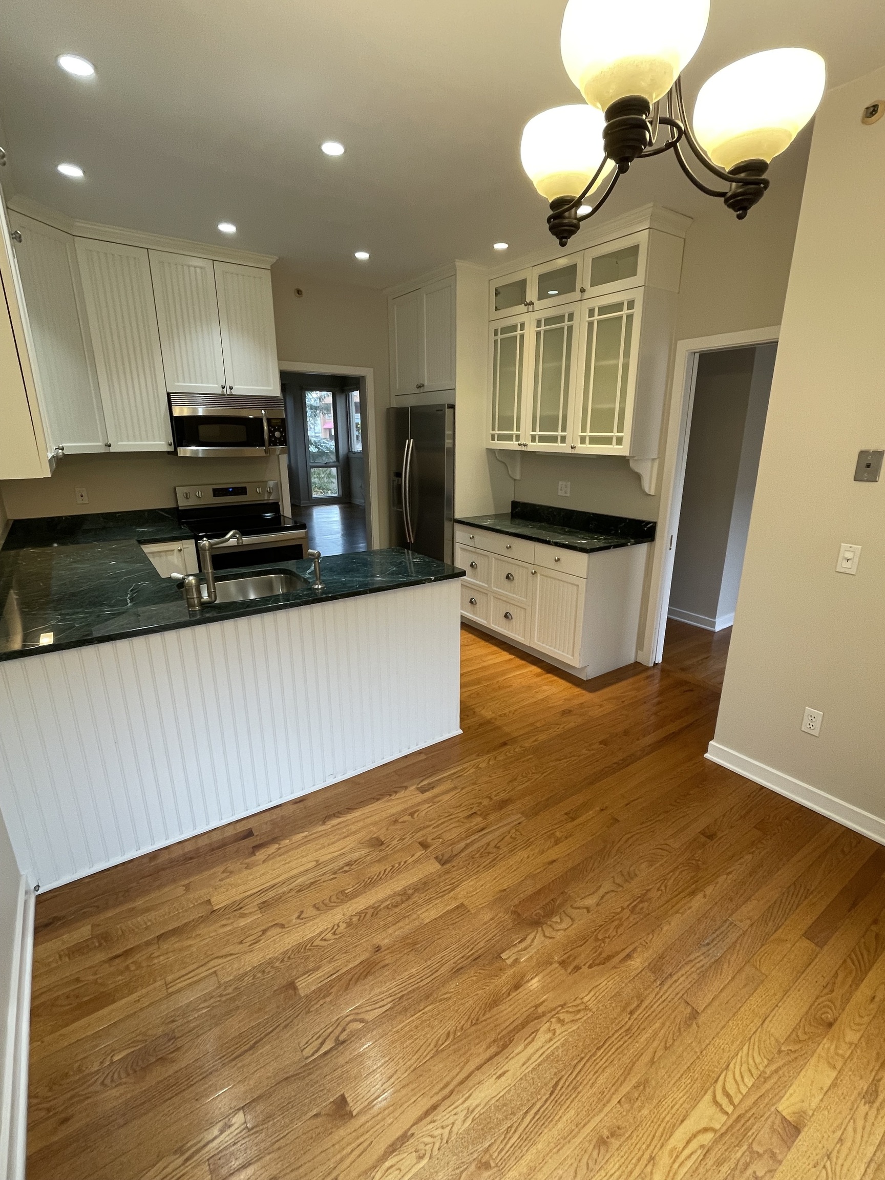 8 Sedgewick Village Lane Darien, CT 06820 - Photo 5 of 15 a kitchen with kitchen island a counter top a stove and a wooden floors
