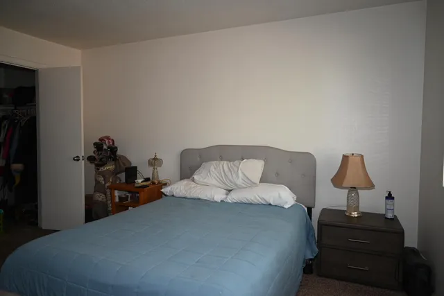 a bedroom with a bed and a lamp on table