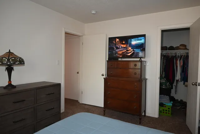 a view of a hallway and closet with wooden floor