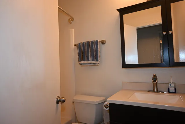 a bathroom with a sink toilet and mirror