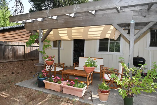 a view of a patio with table and chairs potted plants
