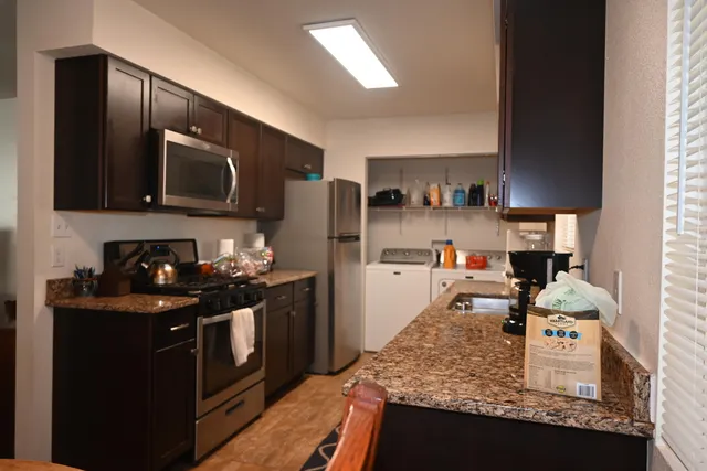 a kitchen with stainless steel appliances granite countertop a sink stove and refrigerator