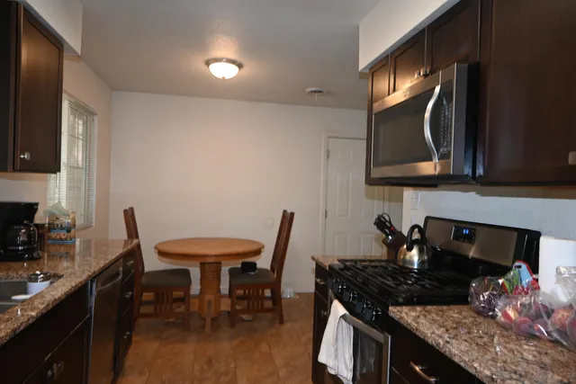 a kitchen with a table chairs sink and cabinets